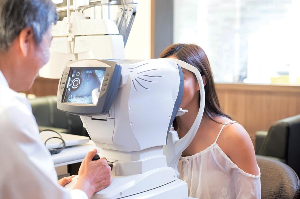 Optometrist giving a young woman an eye exam for ACUVUE® contact lenses fitting, Singapore